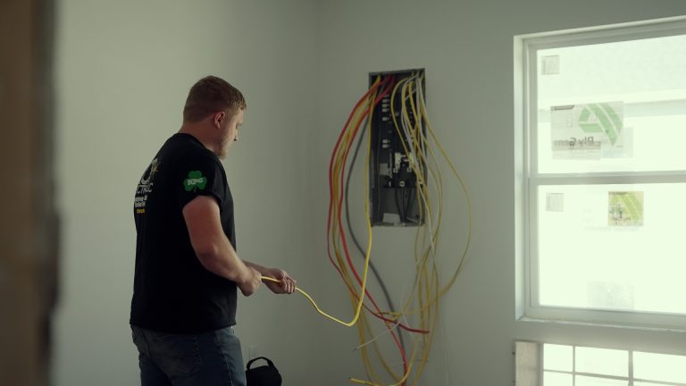 A man stretching out an eletrical line