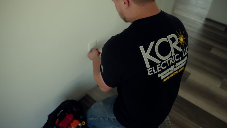 A man installing an outlet in the wall