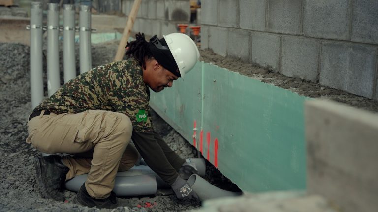 A man installing a drainage system