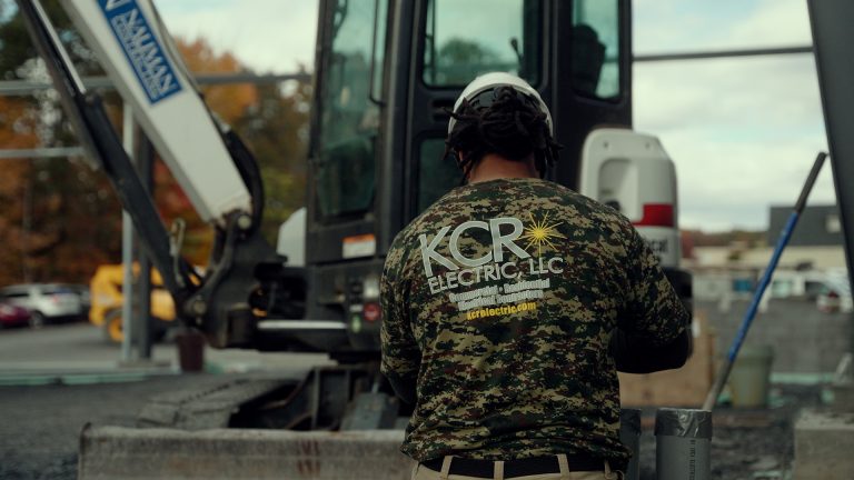 A close up shot of a man in a KCR Shirt Working